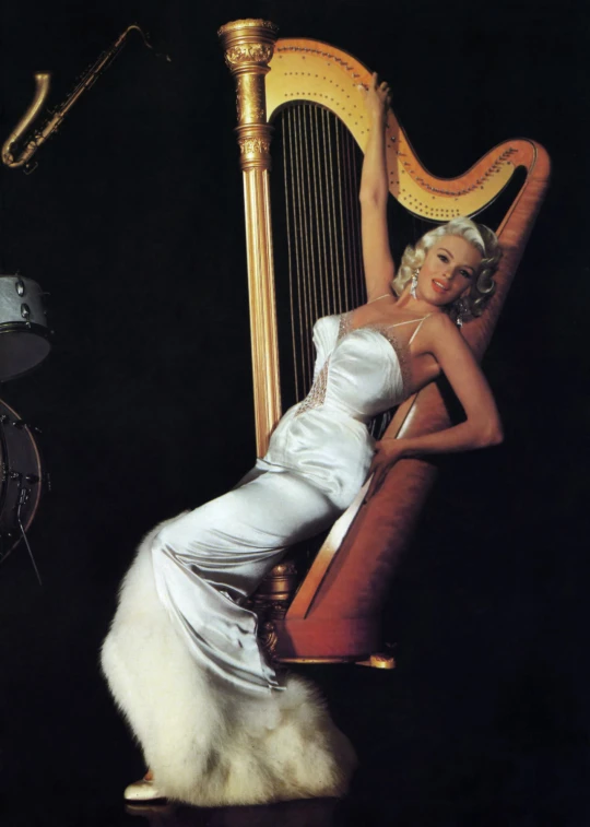 a woman sitting on a stool with her legs crossed next to a harp