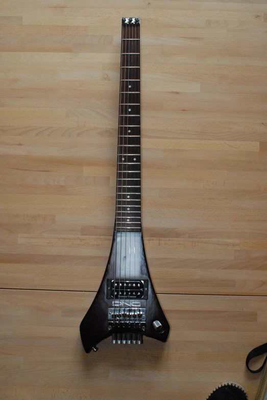 a black guitar sitting on top of a wooden table