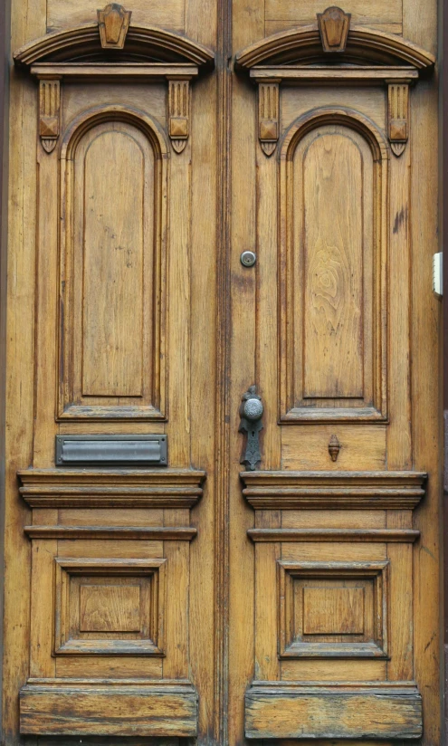 large brown wooden doors with metal s on them