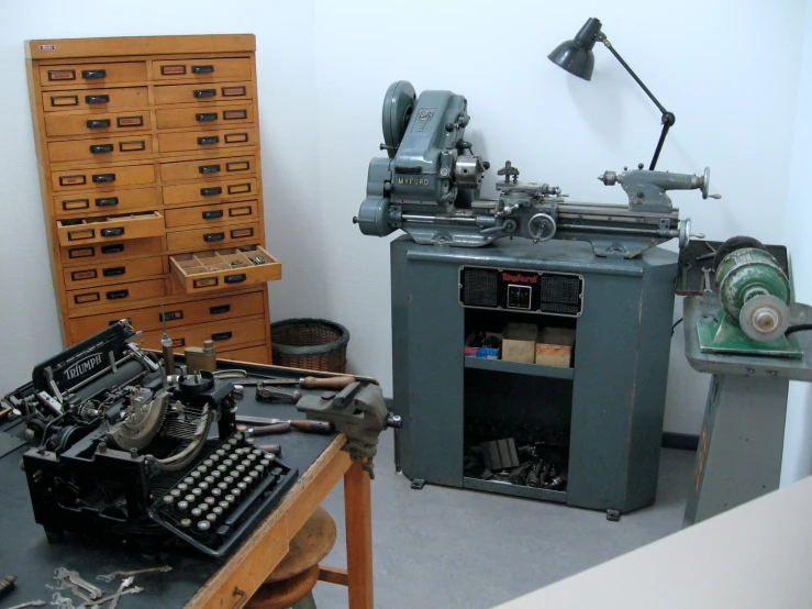 a room with a typewriter, some drawers, and several items