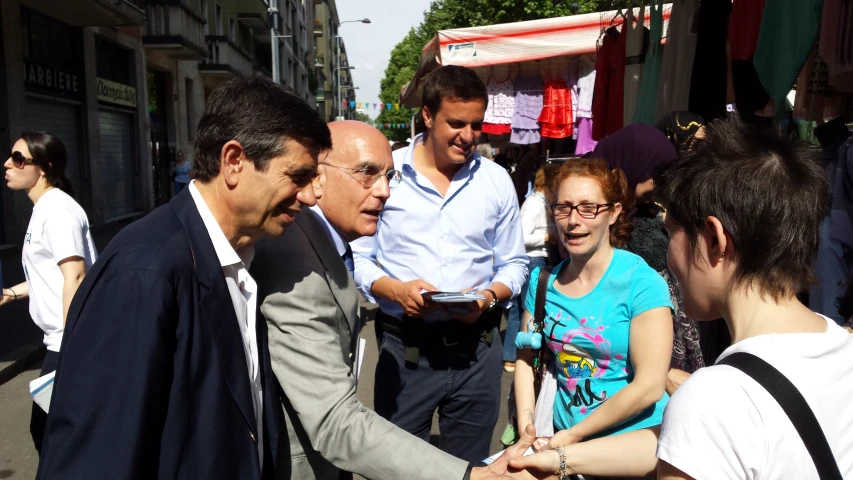 a group of people greeting each other in an outdoor market