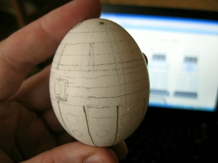 an egg with drawing on the inside of it in someones hand
