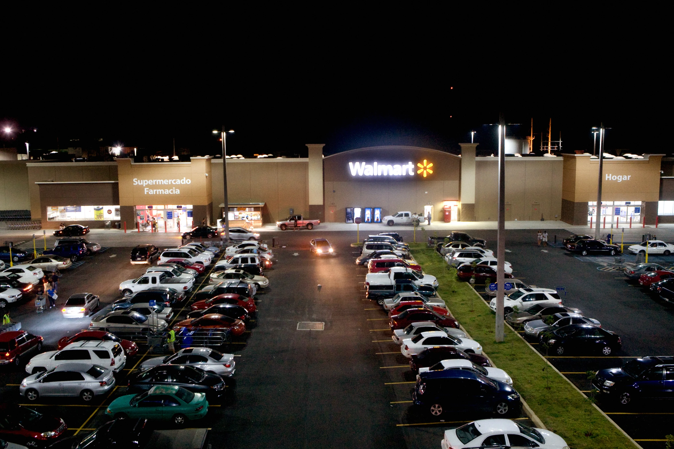 an illuminated parking lot and building at night