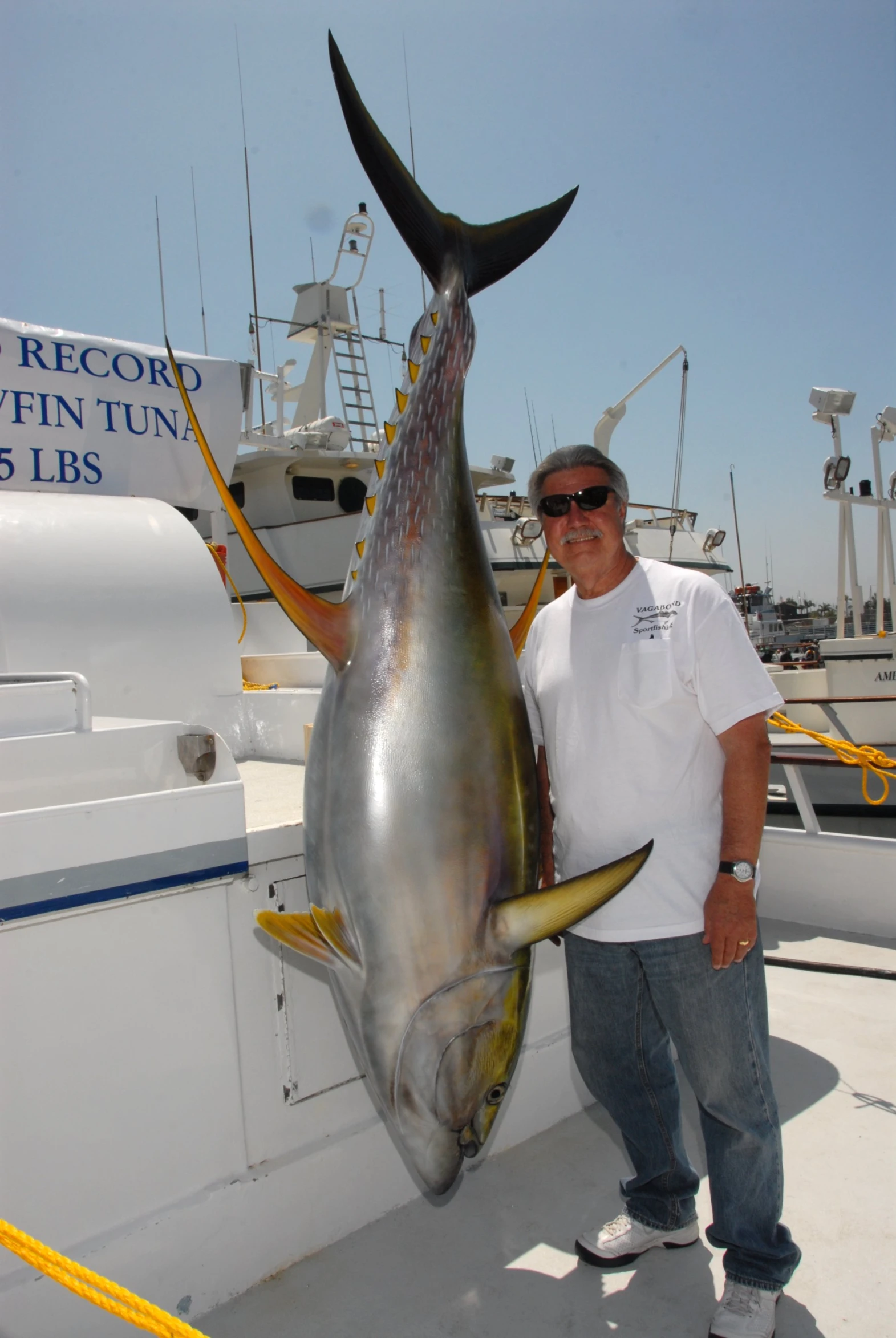 the man is posing with a large fish on the boat