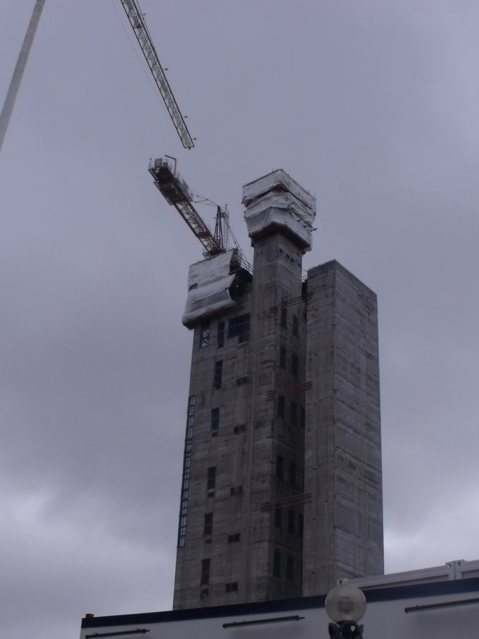 the crane is working in the top floors of the skyscr