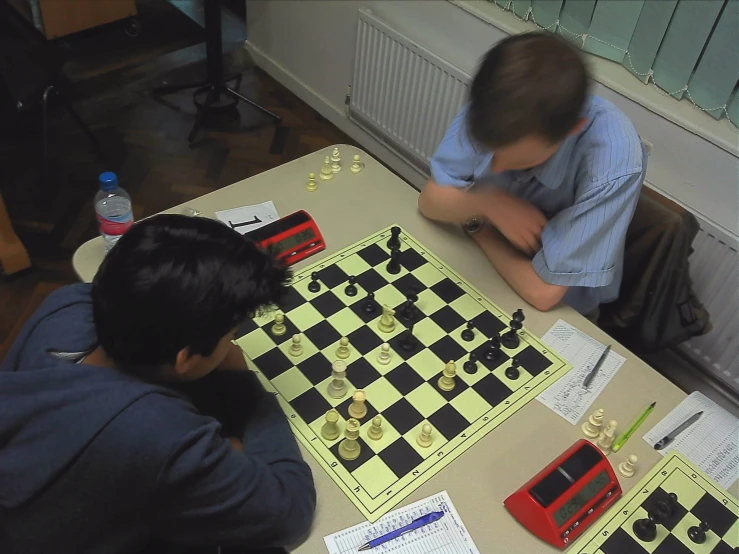 two boys play chess and check out their creations