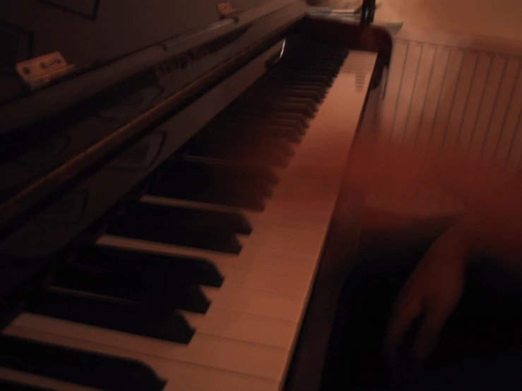 the hands are touching the piano keys in the dark
