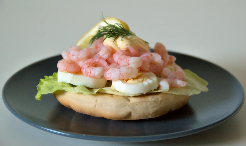 a sandwich with shrimp on top of it on a plate