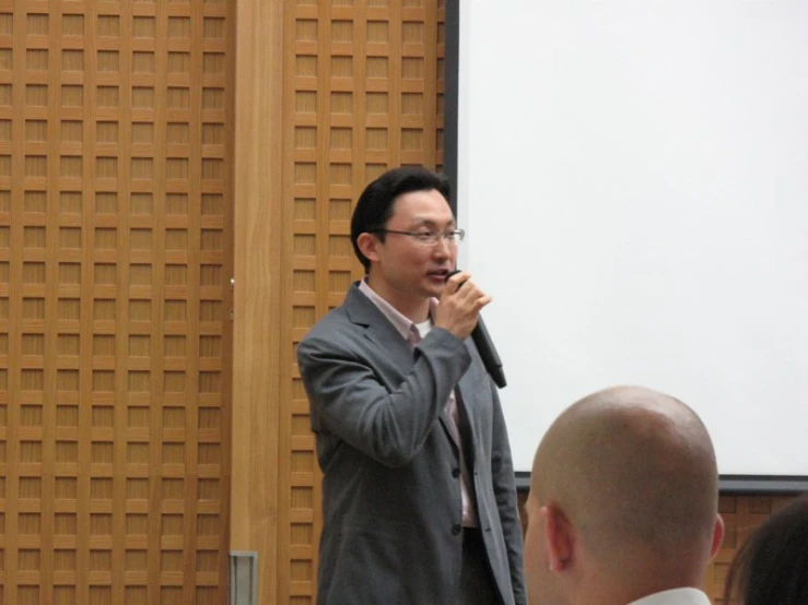 a man stands in front of an audience as he speaks