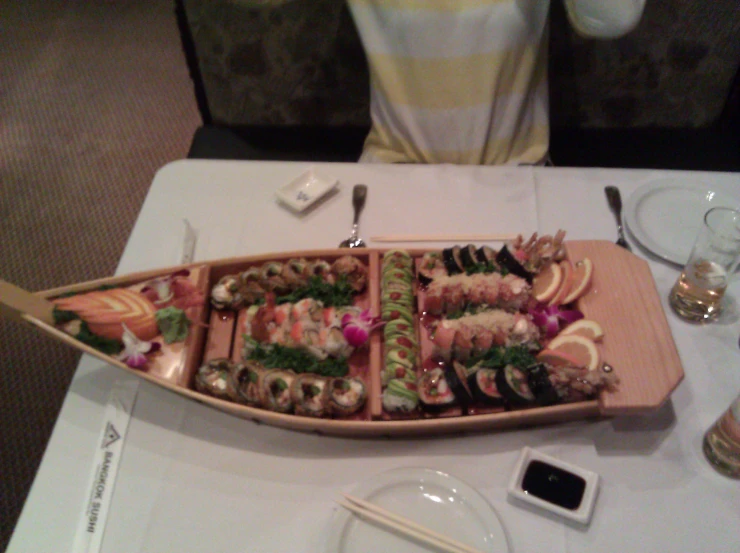 a table has an enormous tray of sushi on it