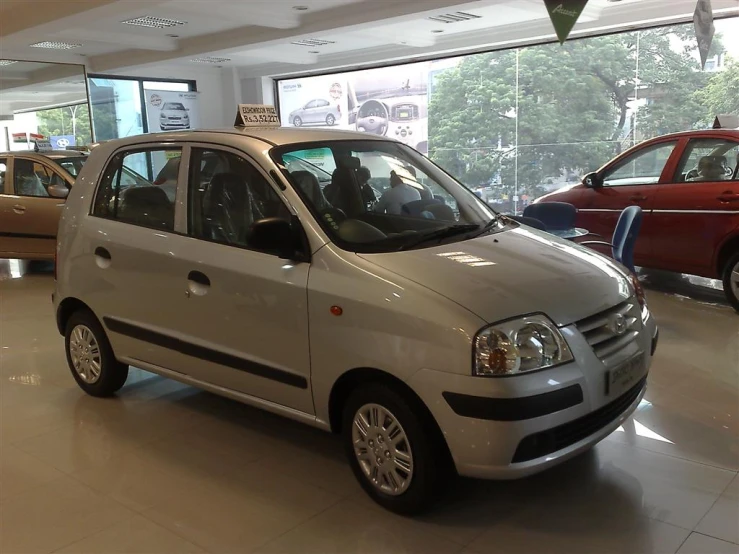 a small white car in a building with other cars