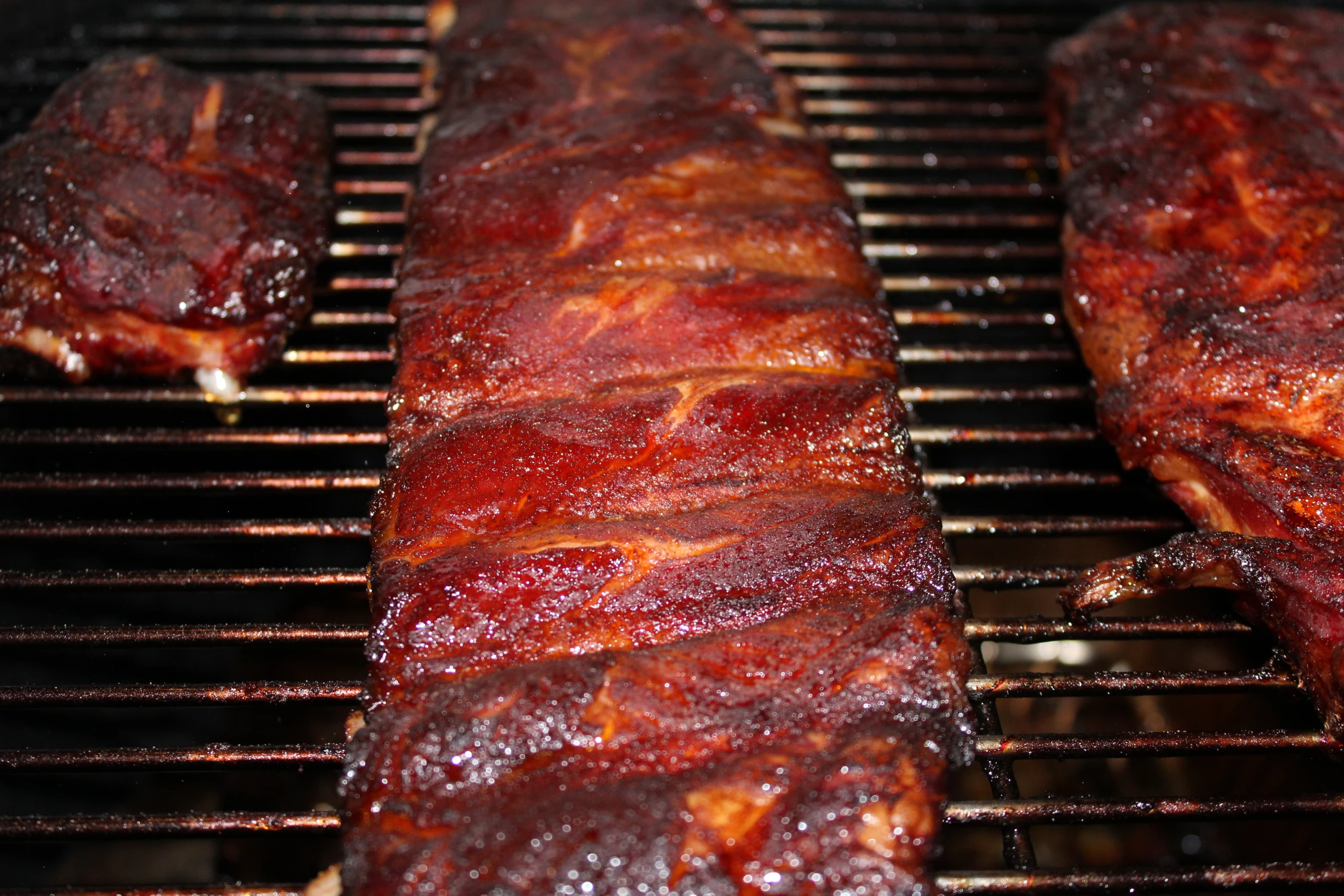 three pieces of ribs sit on top of a grill