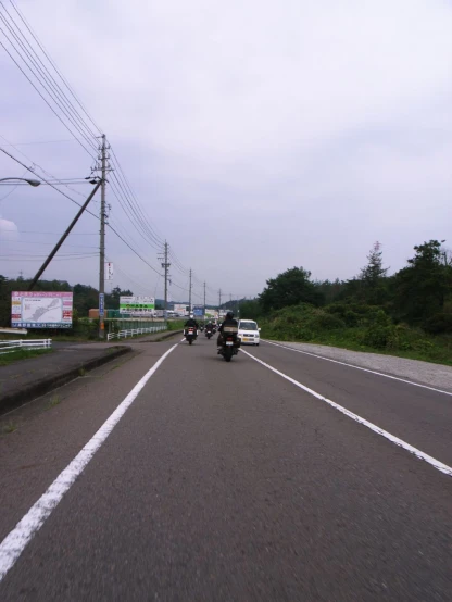 a motorcycle is riding down the road next to two other vehicles