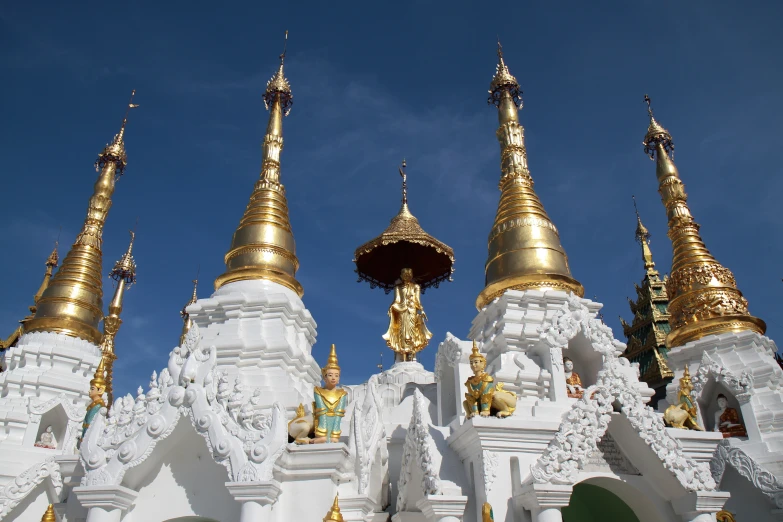 several tall gold domes on a white structure