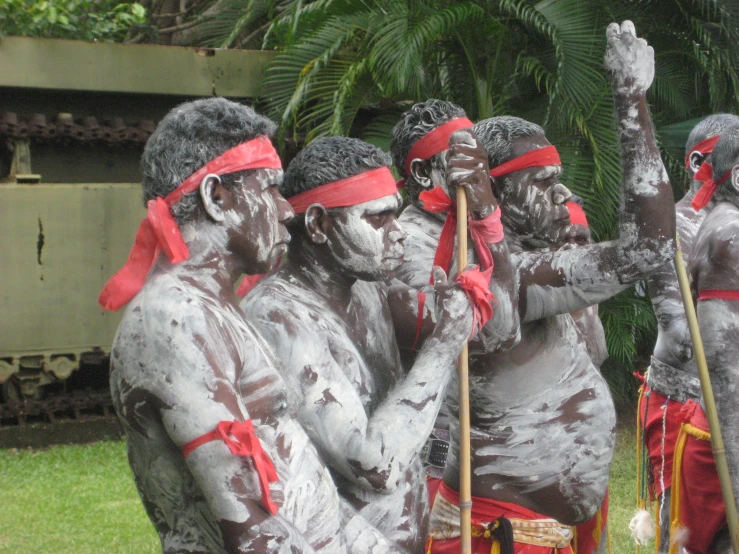 some people with painted face paint and sticks