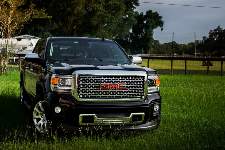 a truck parked on grass next to some trees