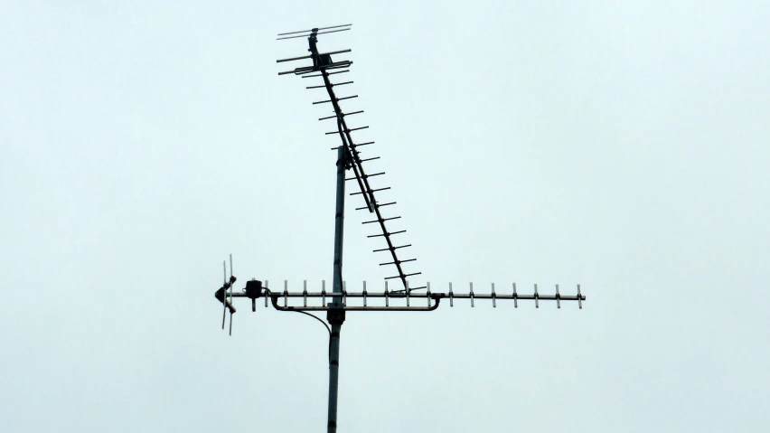 a weather vane with multiple antennas hanging from the top of it