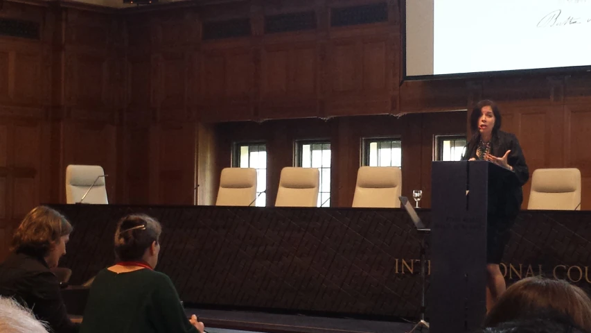 a woman standing at a podium giving a talk