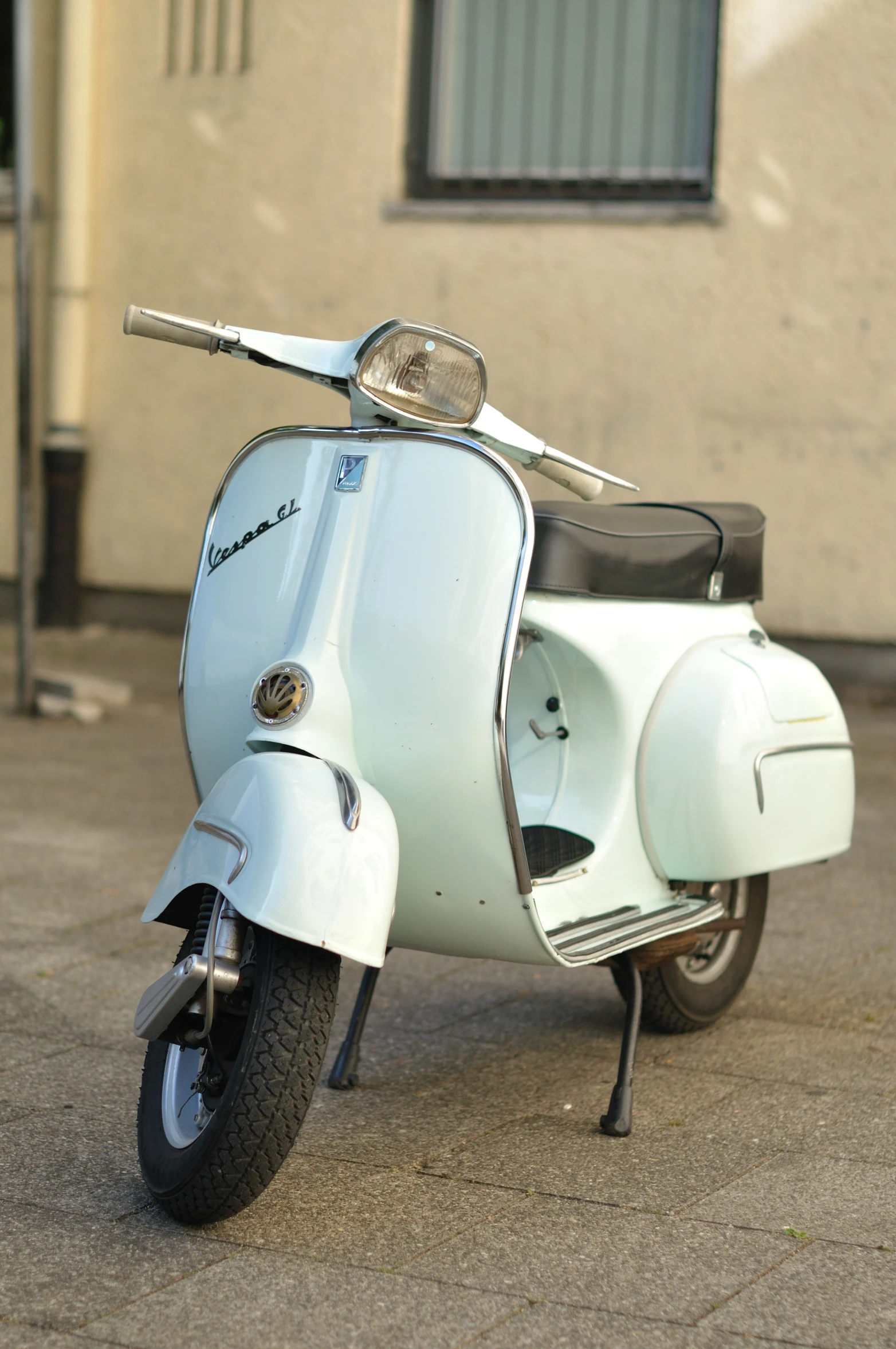 there is a old style moped parked in front of a building