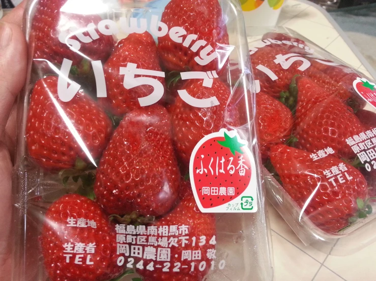 two packages of fresh strawberries are shown in a supermarket
