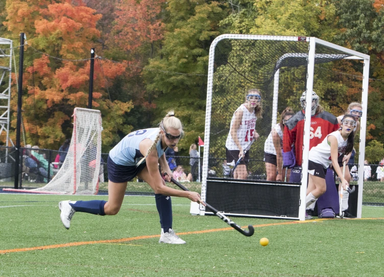 a woman is bending over to hit the ball