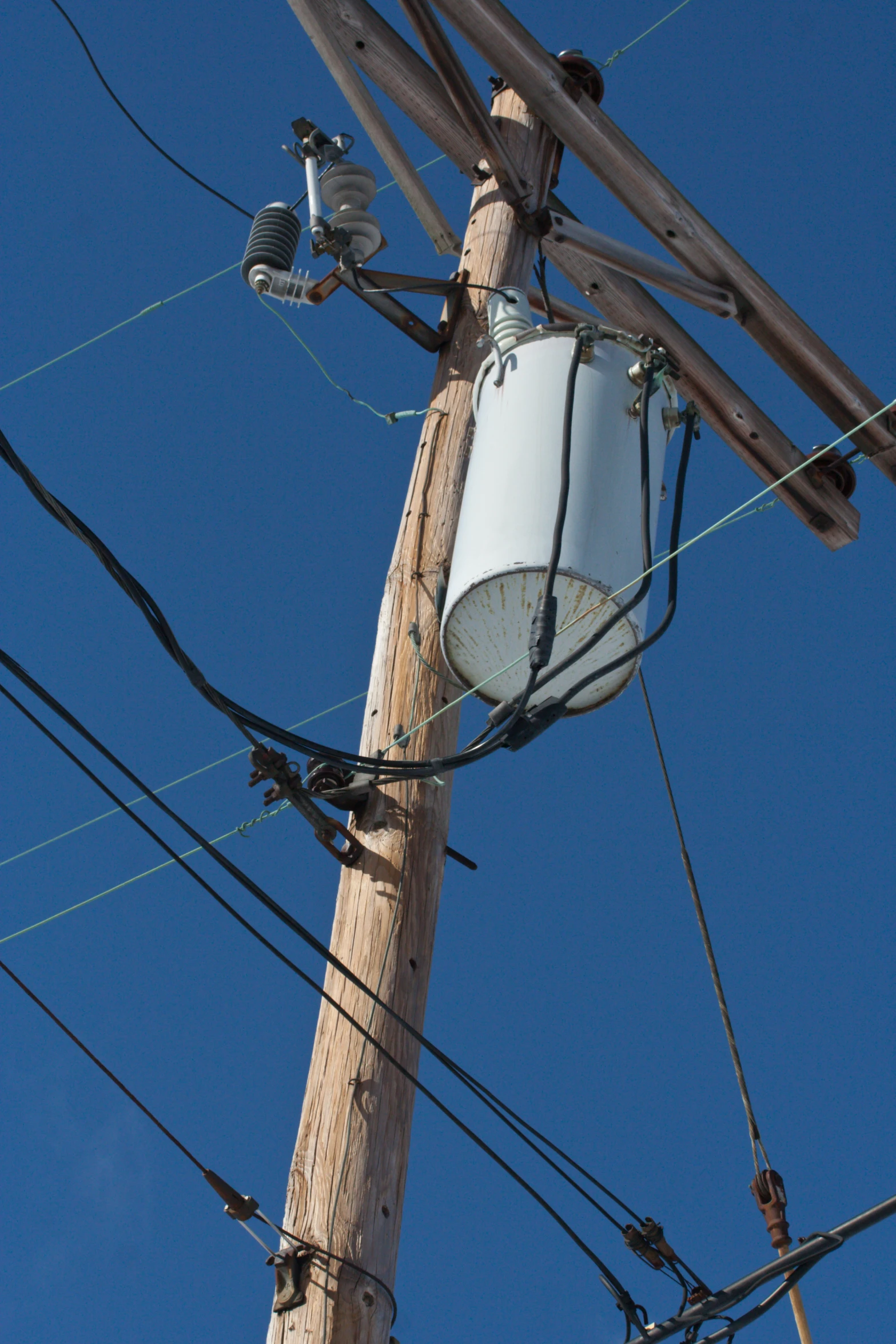 some wires are on top of an old telephone pole