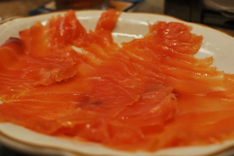 sliced salmon is served in a white dish