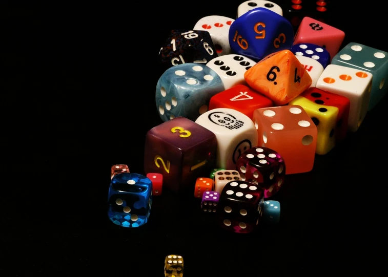 multi colored dices sitting next to each other on a black background