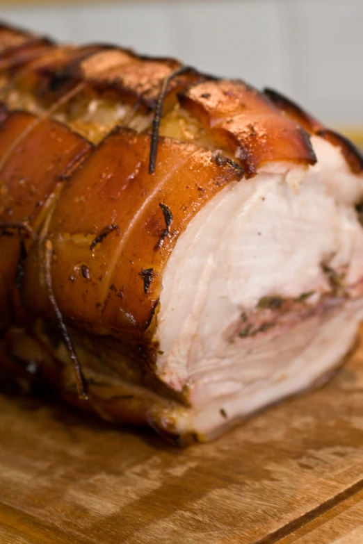 a meat covered in spices on a wooden  board