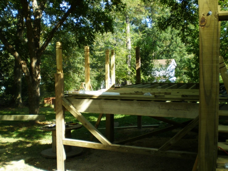 a wooden deck under trees on a sunny day