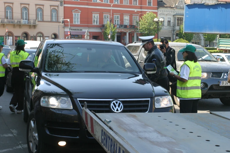 two officers standing on a city street with cars