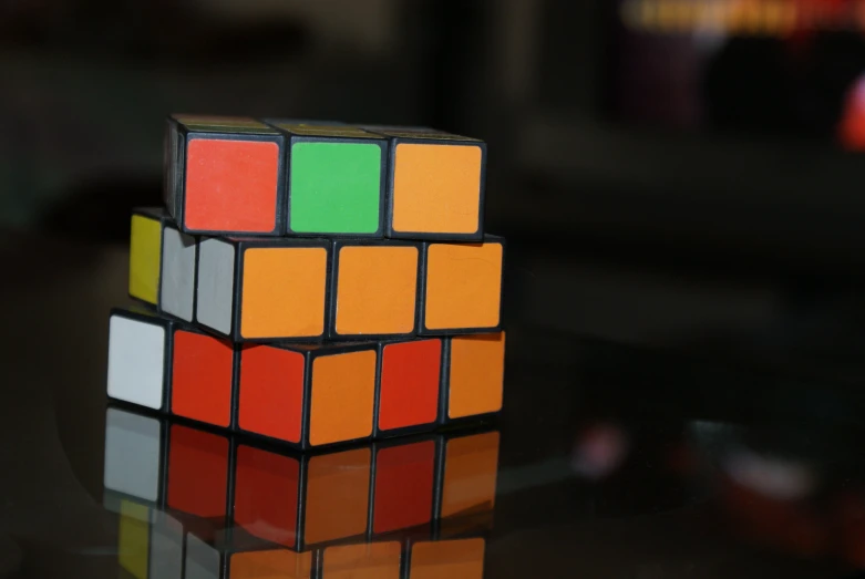 a cube with multi colored squares sitting on top of a table