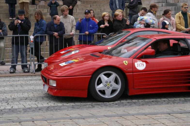 the small sports car is parked near a crowd