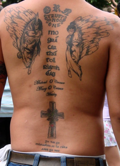 a back view of a man with tattoos on his body