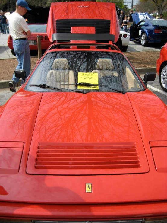 the front of a red sports car with the hood up