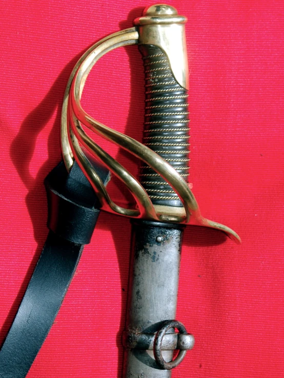 an old sword with gold accents and a black handle