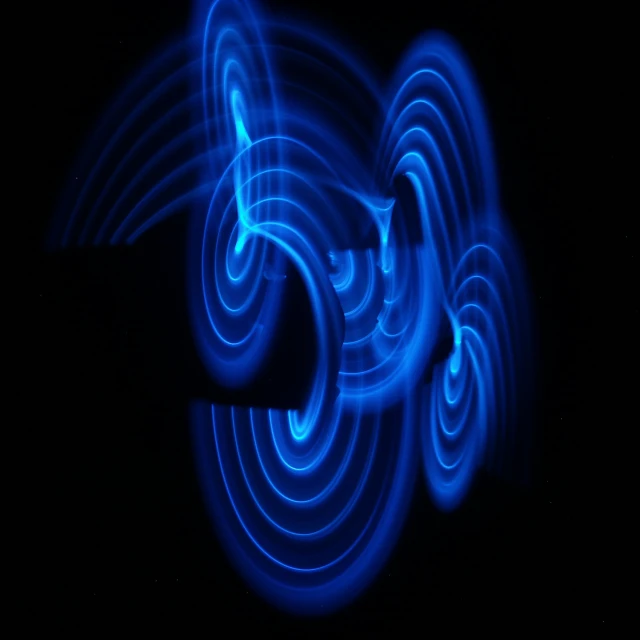 a blue motion blur of swirling waves in black light