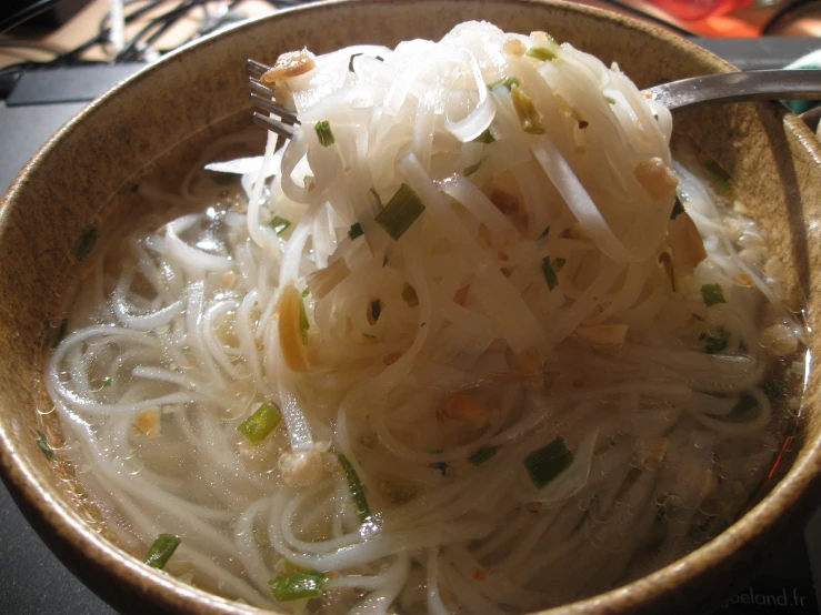 the bowl has noodles in it and with herbs