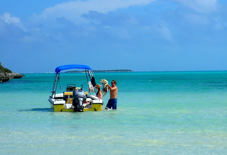 a person standing next to a small boat in the ocean