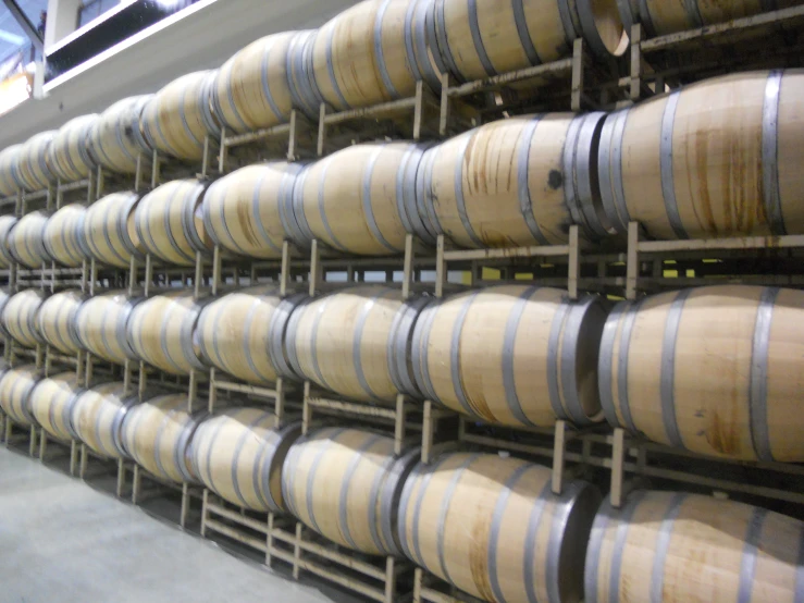 some barrels are stacked up on metal racks