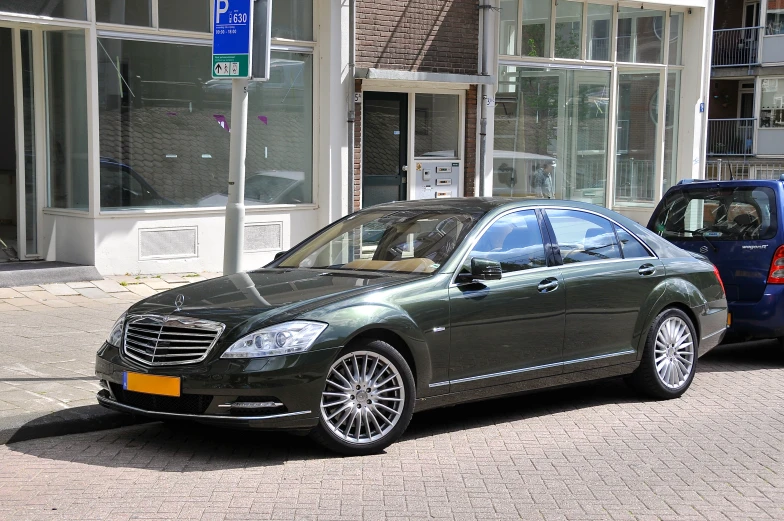 a green car is parked on a city street