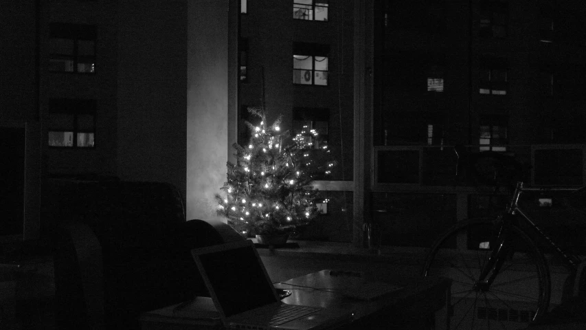 a lit up christmas tree and a chair outside a building