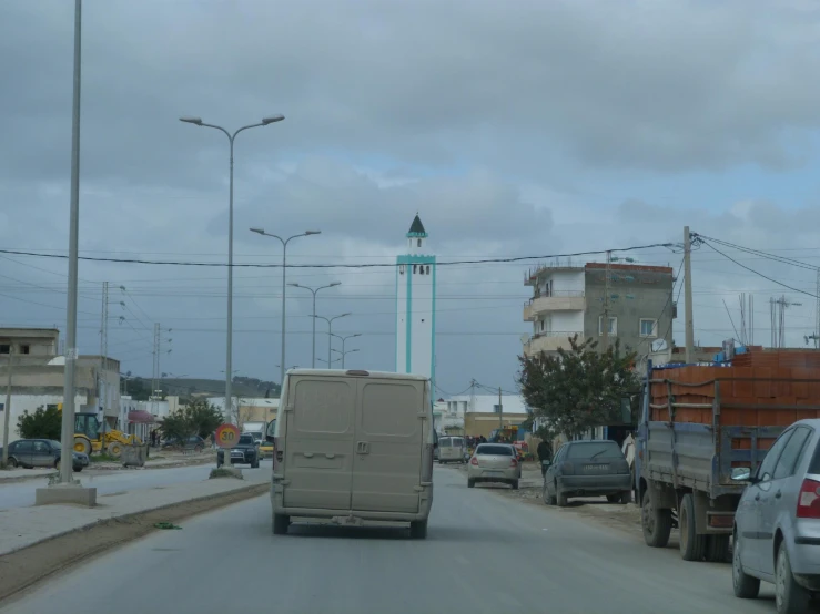 a street full of traffic and a tall tower with a clock on it