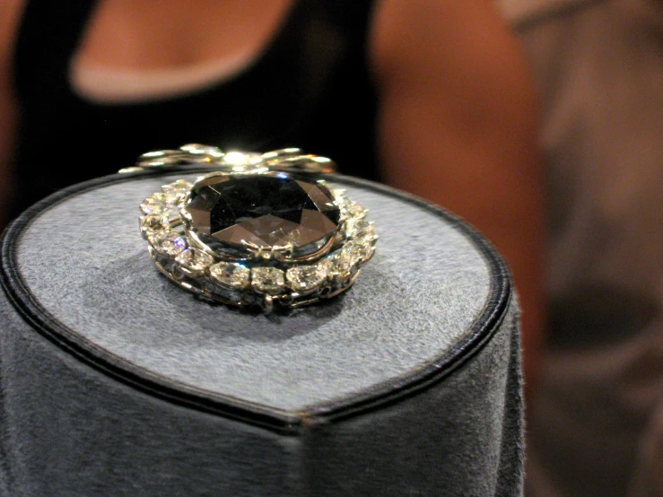 a ring is displayed on a table with the black ring holder