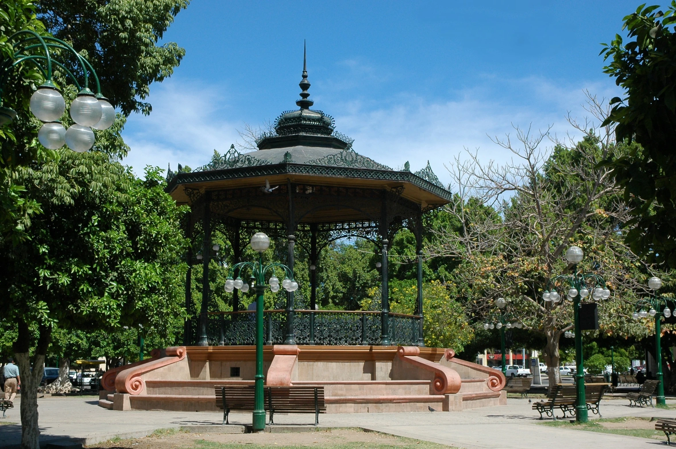 an empty park with a pavilion near some trees