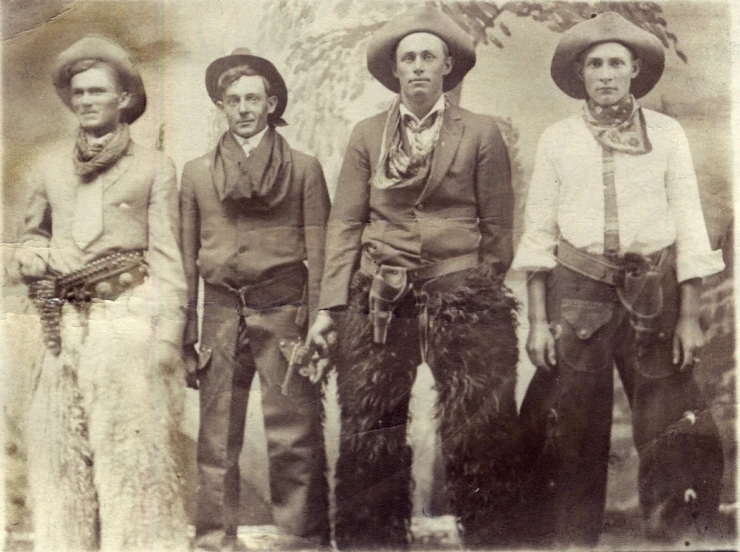 three old timey men with feathered hats posing for a po