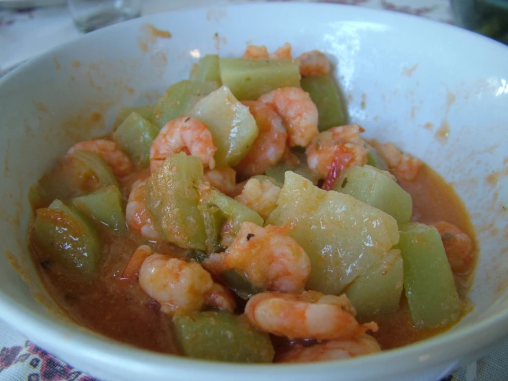 a bowl filled with a mixture of stew with shrimp and celery