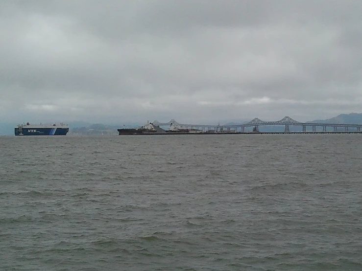 the large boat is near a large bridge