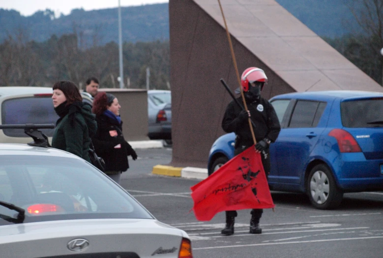 a man walking in a parking lot with a flag on the side