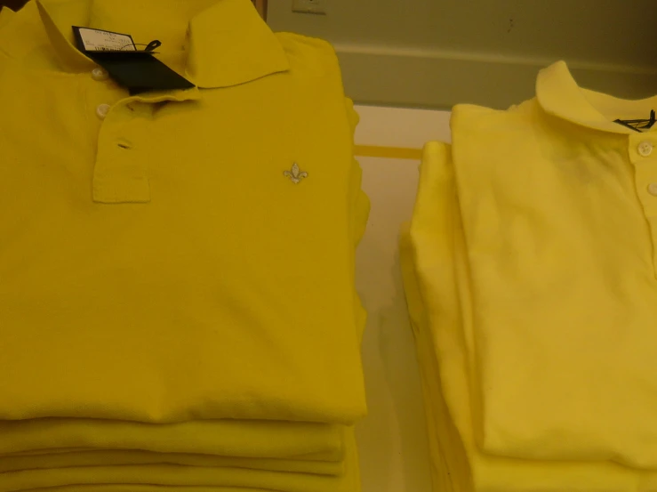 two yellow polo shirts are displayed side by side